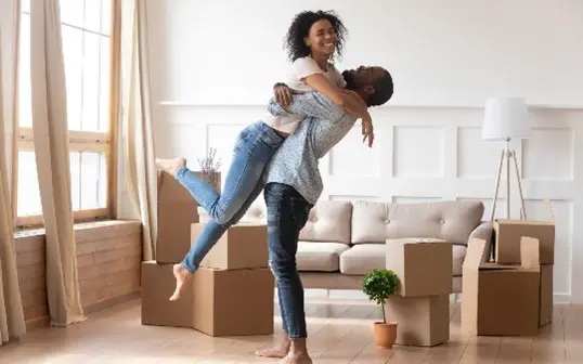 Happy couple in new home with boxes.