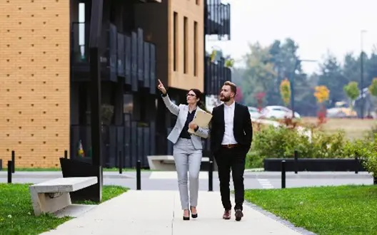 Two business people walking outside building.